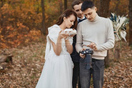 Téléchargez les photos : Les expositions de photographe de mariage juste prises des photos au couple de mariage. mariée et marié dans la nature - en image libre de droit