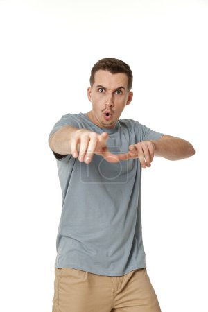 Photo for Surprised guy pointing at the camera on white studio background - Royalty Free Image
