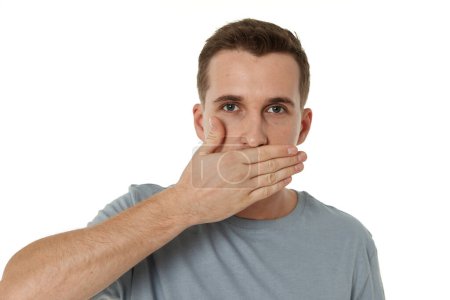 Téléchargez les photos : Homme couvrant la bouche avec les mains sur fond blanc - en image libre de droit