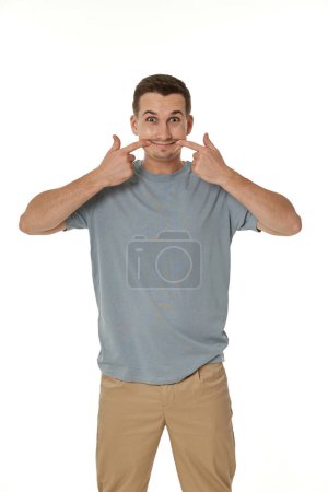 Téléchargez les photos : Portrait de jeune homme drôle grimaçant sur fond blanc - en image libre de droit