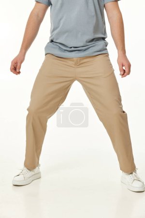 Photo for Man wearing white sneakers and casual beige pants on studio background - Royalty Free Image