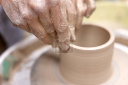 Photo for Male hands making ceramic cup on pottery wheel, Close-up - Royalty Free Image