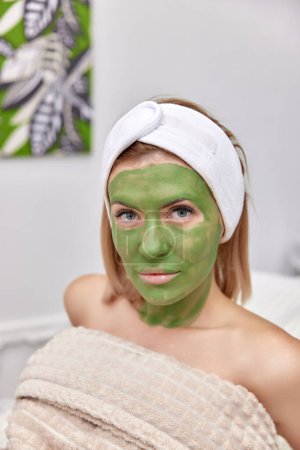 Téléchargez les photos : Belle femme avec masque en alginate vert sur le visage - en image libre de droit