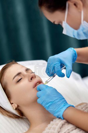 Téléchargez les photos : Esthéticienne fait des injections pour agrandir les lèvres de la belle femme. procédure augmentation des lèvres - en image libre de droit