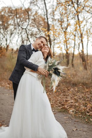 Photo for Smiling bride and groom enjoying romantic moments outside in autumn - Royalty Free Image