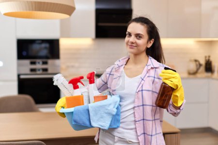 Photo for Woman in rubber protective yellow gloves holding cleaning tools. house chores. - Royalty Free Image