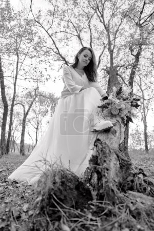 Téléchargez les photos : Belle mariée tenant mariage bouquet d'automne dans la nature. noir et blanc - en image libre de droit