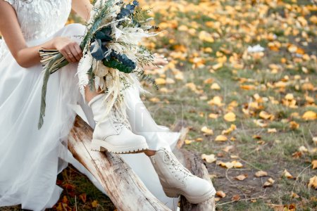 Foto de Novia con botas blancas sosteniendo hermoso ramo de otoño. espacio de copia - Imagen libre de derechos