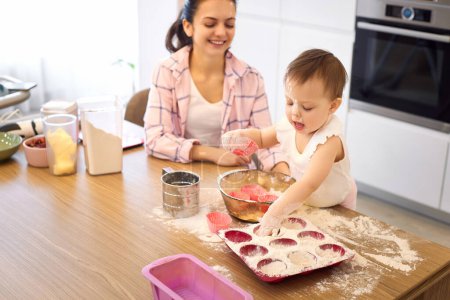 Téléchargez les photos : Mère et petite fille préparant la pâte dans la cuisine, faire cuire les biscuits. heureux temps ensemble - en image libre de droit