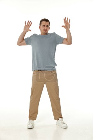 Photo for Scared guy looking at camera on white studio background - Royalty Free Image
