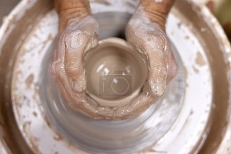 Photo for Male hands making ceramic cup on pottery wheel, Close-up, top view - Royalty Free Image