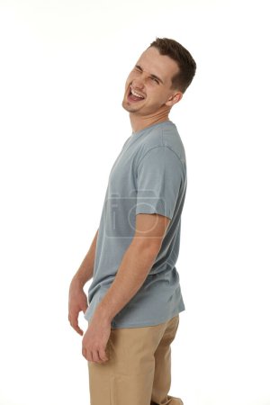Téléchargez les photos : Portrait de jeune homme heureux clin d'oeil en regardant la caméra sur fond blanc - en image libre de droit