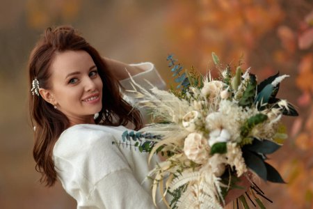 Foto de Retrato de hermosa novia feliz celebración de la boda ramo de otoño en la naturaleza - Imagen libre de derechos