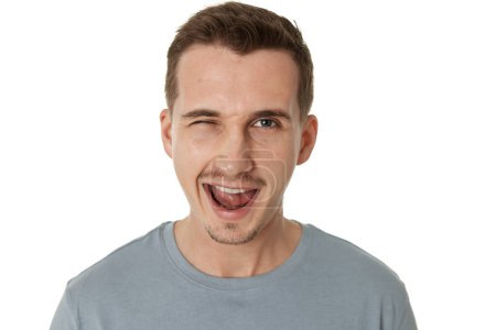 portrait of young happy man winking looking at the camera on white background