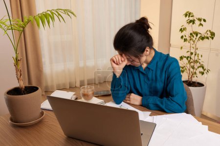 Téléchargez les photos : Stressé femme fatiguée travaillant à l'ordinateur portable à la maison - en image libre de droit