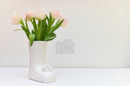 Foto de Ramo de tulipanes en jarrón de conejo de Pascua sobre mesa blanca. espacio de copia - Imagen libre de derechos
