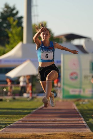 Foto de DENIZLI, TURQUÍA - 16 DE JULIO DE 2022: Atleta indefinido saltando triple durante el Campeonato de Atletismo Balcánico Sub-20 en la pista de atletismo Denizli Albayrak - Imagen libre de derechos
