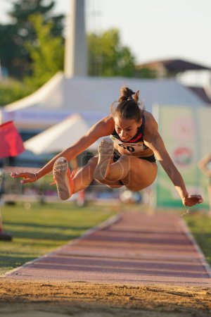 Foto de DENIZLI, TURQUÍA - 16 DE JULIO DE 2022: Atleta indefinido saltando triple durante el Campeonato de Atletismo Balcánico Sub-20 en la pista de atletismo Denizli Albayrak - Imagen libre de derechos