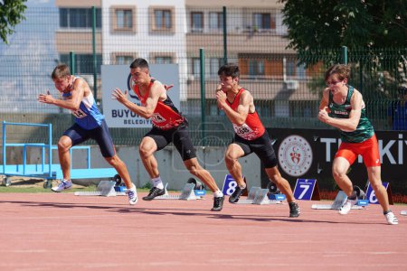 Foto de DENIZLI, TURQUÍA - 17 DE JULIO DE 2022: Atletas corriendo 100 metros obstáculos durante el Campeonato de Atletismo Balcanes Sub-20 en la pista de atletismo Denizli Albayrak - Imagen libre de derechos