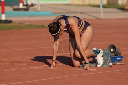 Foto de DENIZLI, TURQUÍA - 17 DE JULIO DE 2022: Atleta indefinido corriendo relevos de 4x400 metros durante el Campeonato de Atletismo de los Balcanes Sub-20 en la pista de atletismo Denizli Albayrak - Imagen libre de derechos