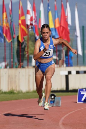 Foto de DENIZLI, TURQUÍA - 16 DE JULIO DE 2022: Atleta indefinido corriendo 400 metros durante el Campeonato Balcánico de Atletismo Sub-20 en la pista de atletismo Denizli Albayrak - Imagen libre de derechos