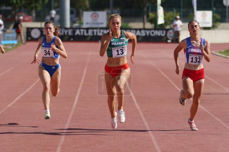 Foto de DENIZLI, TURQUÍA - 17 DE JULIO DE 2022: Atletas corriendo 200 metros durante el Campeonato Balcánico de Atletismo Sub-20 en la pista de atletismo Denizli Albayrak - Imagen libre de derechos