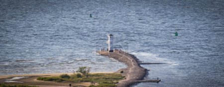 Téléchargez les photos : Swinoujscie, Poméranie occidentale - Pologne - 13 juillet 2022 : Vue depuis le phare de Swinoujscie sur le moulin à vent Stawa Mlyny. Marque de navigation caractéristique - en image libre de droit