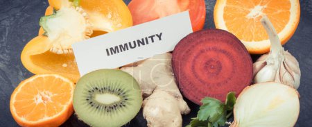 Photo for Inscription immunity with fresh fruits and vegetables. Source natural vitamins, minerals and dietary fiber - Royalty Free Image