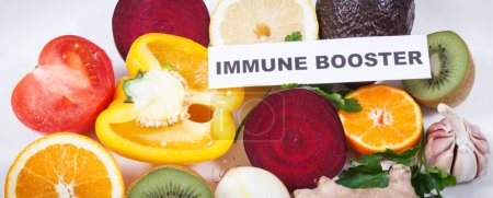 Photo for Inscription immune booster and fresh ripe fruits with vegetables. Source natural healthy vitamins and minerals. Beneficial eating in times of Covid-19 - Royalty Free Image