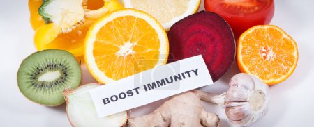Photo for Inscription boost immunity, fresh ripe healthy fruits and vegetables containing natural vitamins. Immune boosting in times of Covid-19 - Royalty Free Image