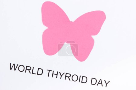 Pinkfarbene Schilddrüsenform aus Papier mit der Aufschrift Weltschilddrüsentag. Schilddrüsenprobleme. Weißer Hintergrund
