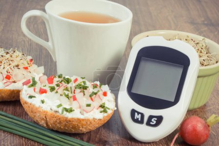 Téléchargez les photos : Glucomètre pour mesurer et vérifier le niveau de sucre, petit déjeuner frais avec thé chaud. Alimentation saine pendant le diabète - en image libre de droit