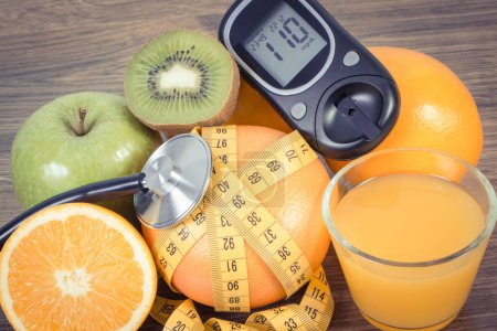 Téléchargez les photos : Glucomètre pour mesurer et vérifier le taux de sucre, les fruits frais mûrs et le jus d'orange. Mode de vie sain et nutrition pendant le diabète - en image libre de droit