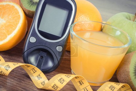 Téléchargez les photos : Glucomètre pour mesurer et contrôler le taux de sucre, les fruits frais mûrs et le jus d'orange. Source de minéraux naturels et de vitamines - en image libre de droit