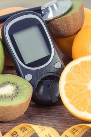 Téléchargez les photos : Glucomètre pour mesurer et vérifier le taux de sucre et les fruits frais mûrs. Source de minéraux naturels et de vitamines - en image libre de droit