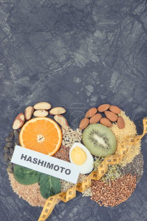 Inscription hashimoto with nutritious natural ingredients, fruits and vegetables in shape of thyroid. Healthy lifestyles and food containing vitamins and minerals. Place for text or inscription