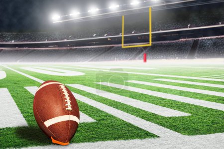American football stadium with goal post and ball on tee ready for field goal kick. Focus on foreground ball with shallow depth of field on background and copy space.