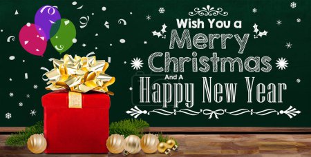 Photo for Christmas decoration background with gift box and  chalkboard Merry Christmas message, decorated pine leaves and baubles on wood table with copy space. - Royalty Free Image