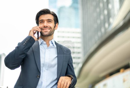 Foto de Primer plano de un joven caucásico hombre serio usando un dispositivo de teléfono inteligente moderno mientras espera a su amigo en una zona pública. - Imagen libre de derechos