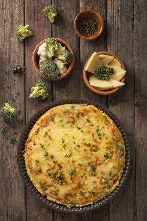 Photo for Table top shot of a fresh vegetarian pie served on a cutting board on rustic wooden table - Royalty Free Image
