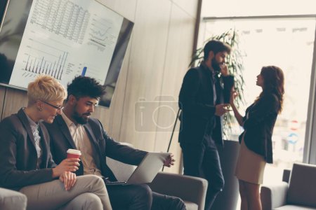 Téléchargez les photos : Les gens d'affaires discutent de questions liées au travail pendant une pause café. Concentre-toi sur l'homme assis - en image libre de droit