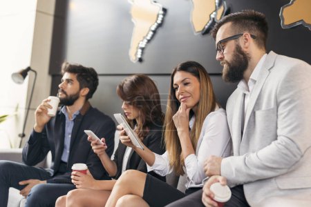 Photo for Business people sitting in an office building waiting room, on a coffee break during a presentation. Focus on the woman on the right - Royalty Free Image