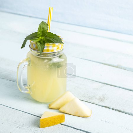 Téléchargez les photos : Jus de melon froid servi dans un bocal, décoré de feuilles de menthe et de tranches de melon - en image libre de droit
