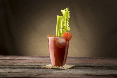 Téléchargez les photos : Cocktail Bloody Mary avec vodka, jus de citron et de tomate, sauce tabasco et glaçons décorés de feuilles de céleri - en image libre de droit