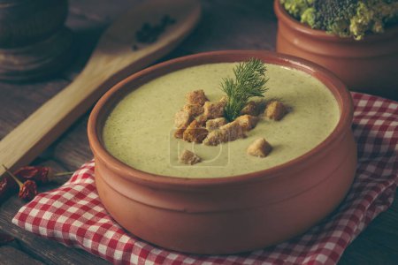 Photo for High angle view of fresh creamy broccoli soup decorated with croutons and fresh dill leaves. Selective focus on the dill leaves and croutons - Royalty Free Image