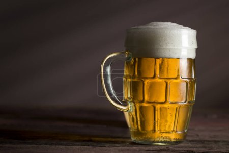Photo for Jug of cold pale beer placed on a rustic wooden table - Royalty Free Image