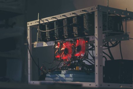 Photo for Mining rig for cryptocurrency digging set up and operational. Selective focus on the cooler and a GPU - Royalty Free Image