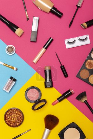Photo for Flat lay of various make up products on colorful background. Make up brushes, blushes, face powders, corrector, highlighters, lip gloss, lipstick, mascara, eyeliner and eyelashes - Royalty Free Image