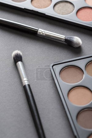 Photo for High angle view of an eyeshadow palette and an eyelid make up brush - Royalty Free Image
