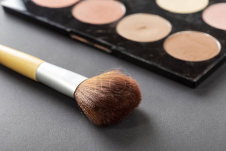 Photo for High angle view of face powder palette and a make up brush isolated on black background - Royalty Free Image